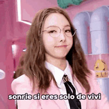 a girl wearing glasses and a pink jacket is smiling and says sonrie si eres solo de vivi