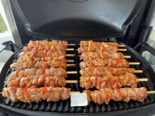 chicken skewers are being cooked on a grill with a note that says " for sale "