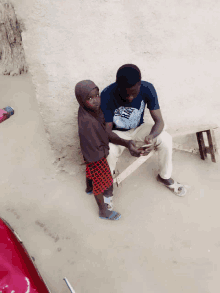 a little girl sits next to a man wearing a t-shirt that says ' nike ' on it