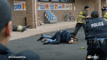 a man is laying on the ground in front of a store with a sign that says corn on it