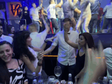 a group of people are dancing in a club with a sign that says love in the background