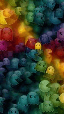 a bunch of colorful pac man ghosts are floating in the air .