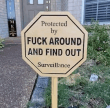 a wooden stop sign that says protected by fuck around and find out surveillance