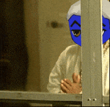 a person with a blue mask on their face is behind a window