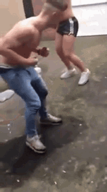 a shirtless man is dancing with a woman in shorts .