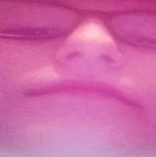 a close up of a person 's face on a pink background .