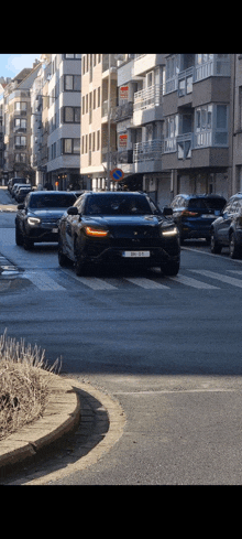 a row of cars are driving down a street with a building with a sign on it that says ' alquiler '