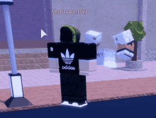 a person wearing a black adidas shirt is standing on a street