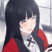 a girl with long black hair and a red jacket is sitting in front of a window holding a cell phone .