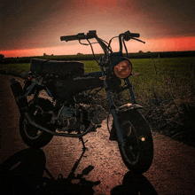 a honda motorcycle is parked on the side of the road at sunset