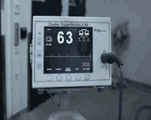 a cardiac monitor is sitting on a table in a hospital room .