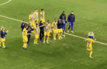 a group of soccer players are standing on a field and one of them is wearing a blue and white striped shirt