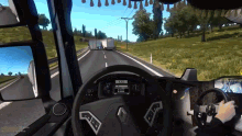 a screenshot of a video game shows the steering wheel and dashboard of a renault truck