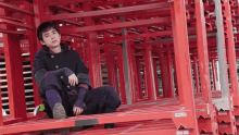 a man sits on a stack of red shelves with a sticker that says ' a ' on the bottom