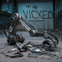 a robotic arm is laying on the ground in front of a wall that says " it is vicxed "