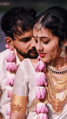 a bride and groom are standing next to each other in the rain .