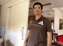 a man wearing a european league shirt stands in a room