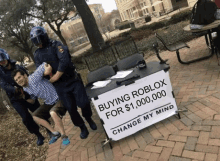 a man is being arrested in front of a table that says buying roblox for $ 1,000,000