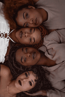 four women are laying in a circle with one wearing a necklace with the name barbie on it