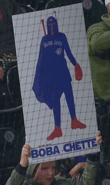 a boy holding a boba chette sign in a stadium