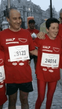 a man and a woman wearing red shirts with the number 24014 on them