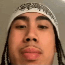 a close up of a man 's face wearing a bandana and a hat .