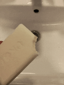 a person is holding a bar of dove soap over a sink