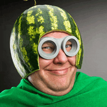 a man wearing a watermelon hat and goggles smiles