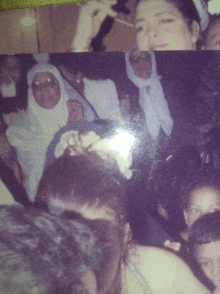 a woman in a white head scarf is surrounded by people