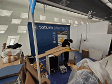 a man is working in front of a sign that says totum pharmacie