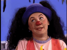 a woman dressed as a clown with pigtails and a purple hat