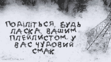 an aerial view of a snowy field with a russian message written in the snow