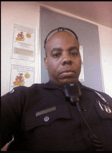 a police officer is taking a selfie in front of a wall with posters on it that say thanksgiving