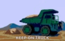 a dump truck is driving down a dirt road with the words `` keep on truck '' below it .