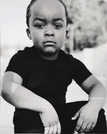 a black and white photo of a young boy sitting down