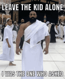 a man with a beard is standing in front of a crowd with a caption that says leave the kid alone