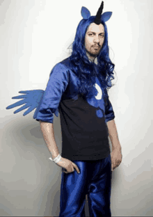 a man with long blue hair is dressed as a unicorn with wings