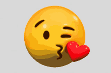 a yellow smiley face is blowing a kiss with a red heart in its mouth