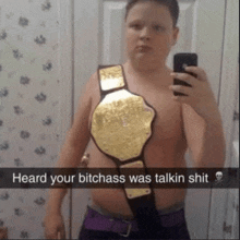 a young boy is taking a selfie with a wrestling belt around his waist and the caption heard your bitchass was talkin shit