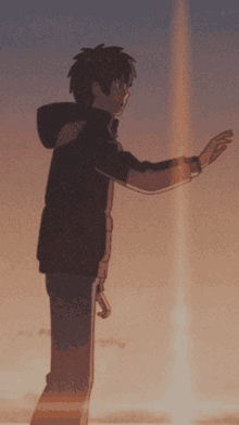 a man in a black jacket stands in front of a sunset with his hands outstretched