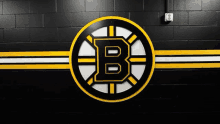 a logo for the boston bruins is on a black brick wall .