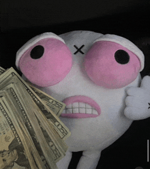 a stuffed animal is holding a stack of 20 dollar bills in front of its face