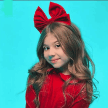 a little girl wearing a red dress and a red headband