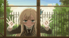 a girl with blonde hair is looking out a window with her hands on the glass