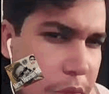 a close up of a man 's face with a cigarette in his mouth .