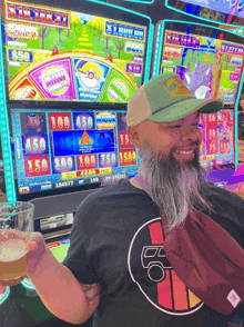 a man with a beard holds a glass of beer in front of a slot machine that says $ 1000 on it