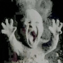 a close up of a ghost with its mouth open and its hands up in the air .