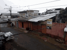 an aerial view of a slum area with a sign on the side of the road that says " atencion "