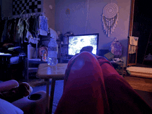 a bottle of aquafina water sits on a table in front of a television