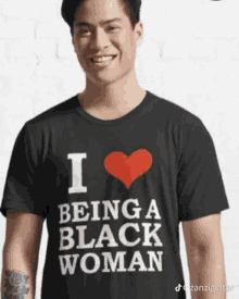 a man is wearing a black t-shirt that says i love being a black woman